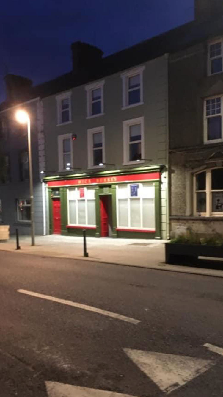 The crimson and sage facade of Mick Burke's pub in Buttevant